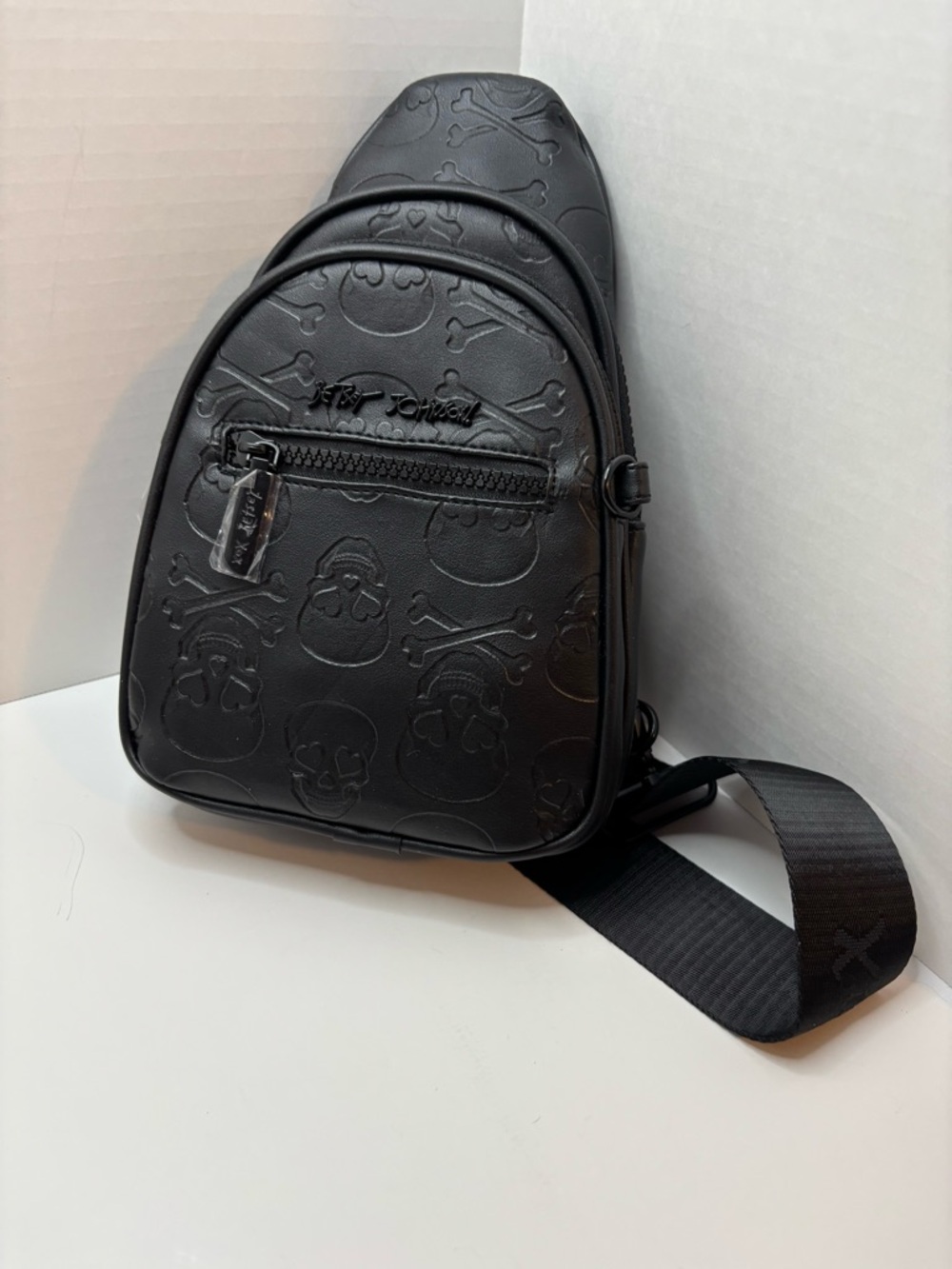 Betsey Johnson Black Skull-Embossed Sling backpack XOALLIE